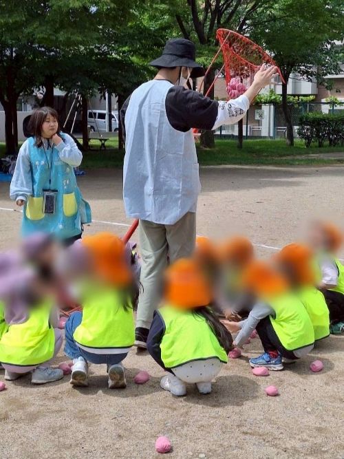 公園で玉入れの練習をする園児たちと保育士を目指す専門学生の様子